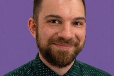 headshot of adam poltrack against an nyu purple background